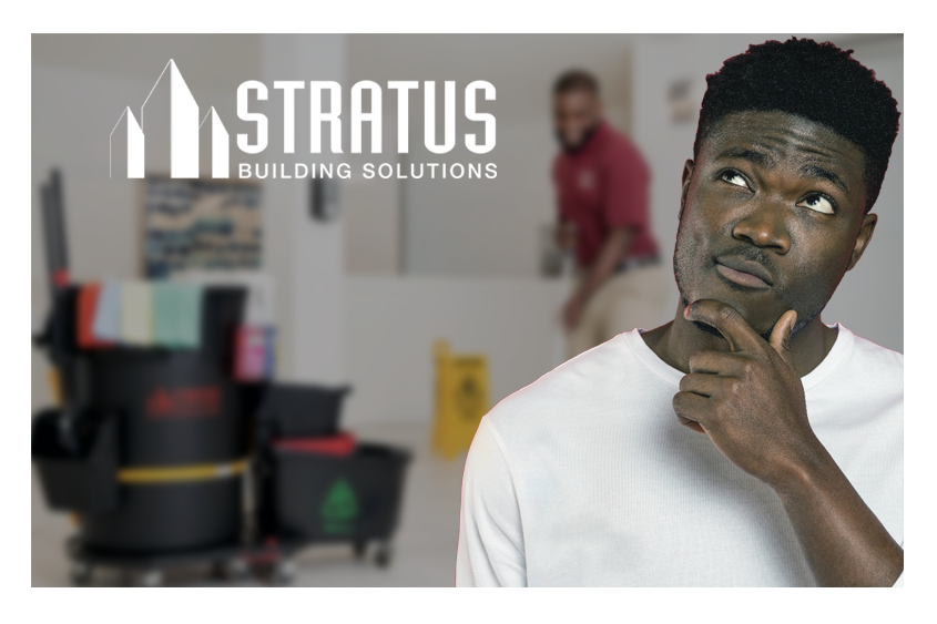 A man holding his hand to his chin while looking up with a quizzical expression with a janitor and janitorial supplies in the background.